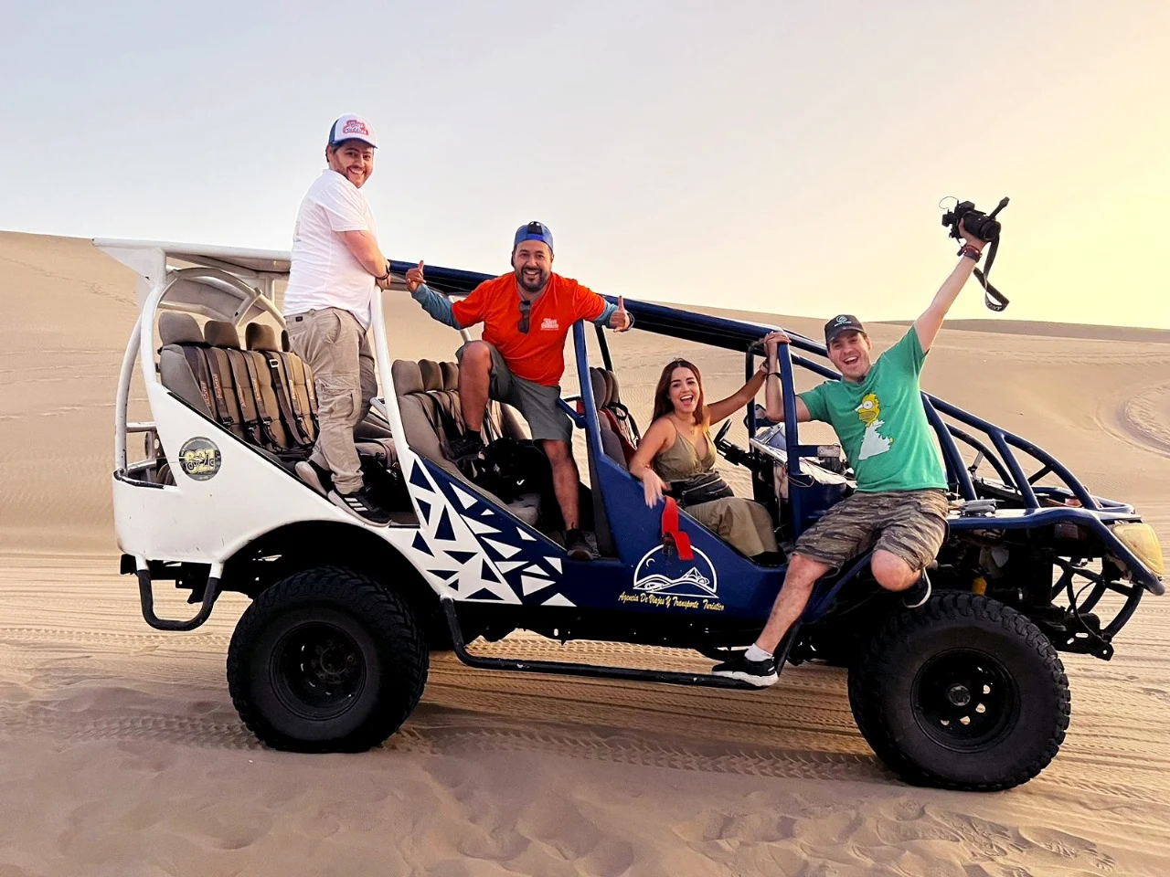 Viajeros haciendo sandboard en las dunas de Huacachina